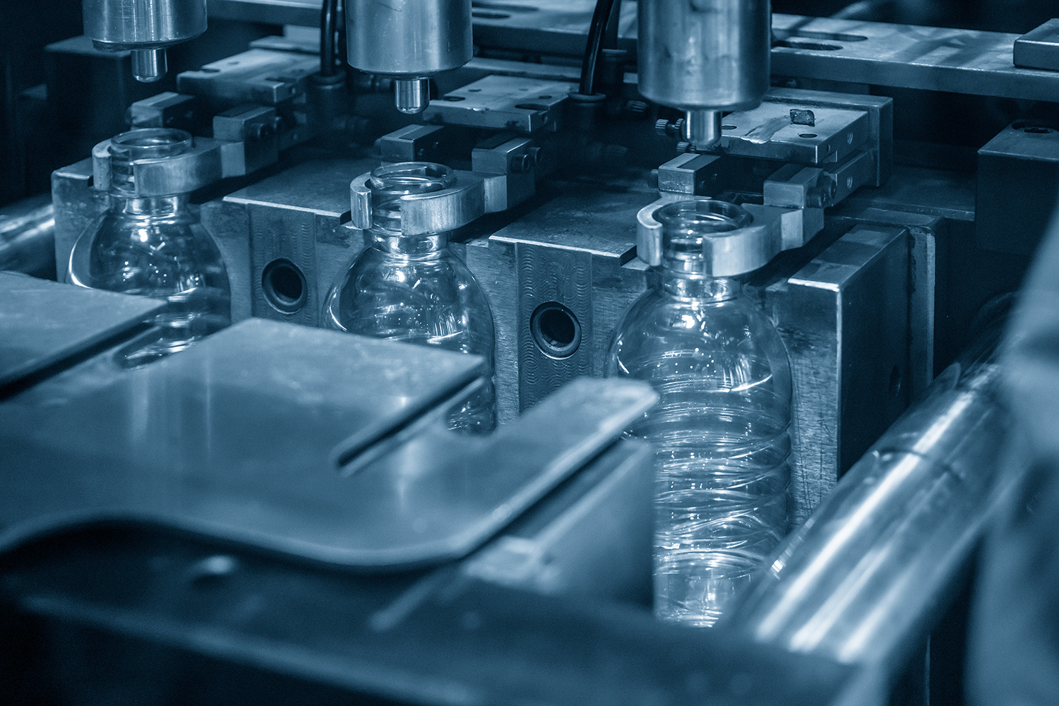 A closeup of an industrial bottle-molding machine.