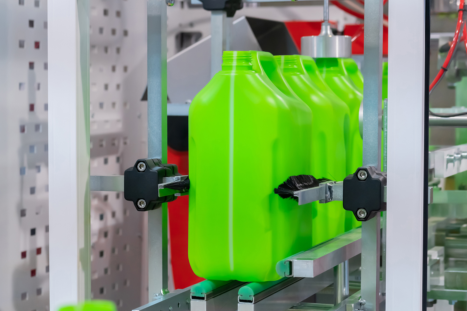 A series of bright green molded plastic bottles on the production line