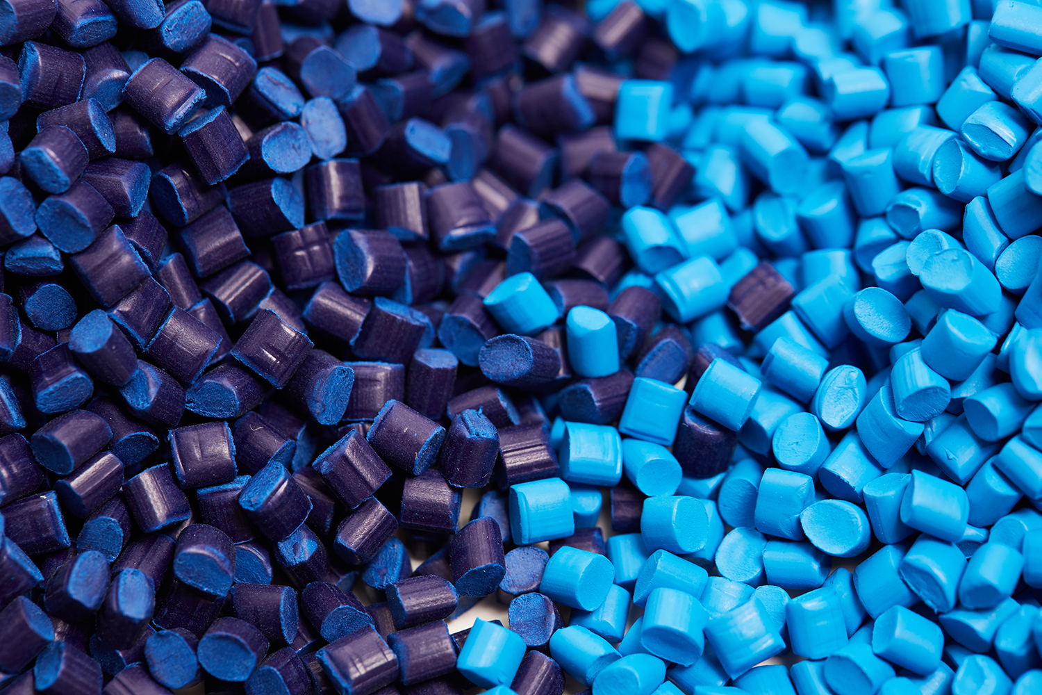 a closeup of dark and light blue plastic granules used in injection molding