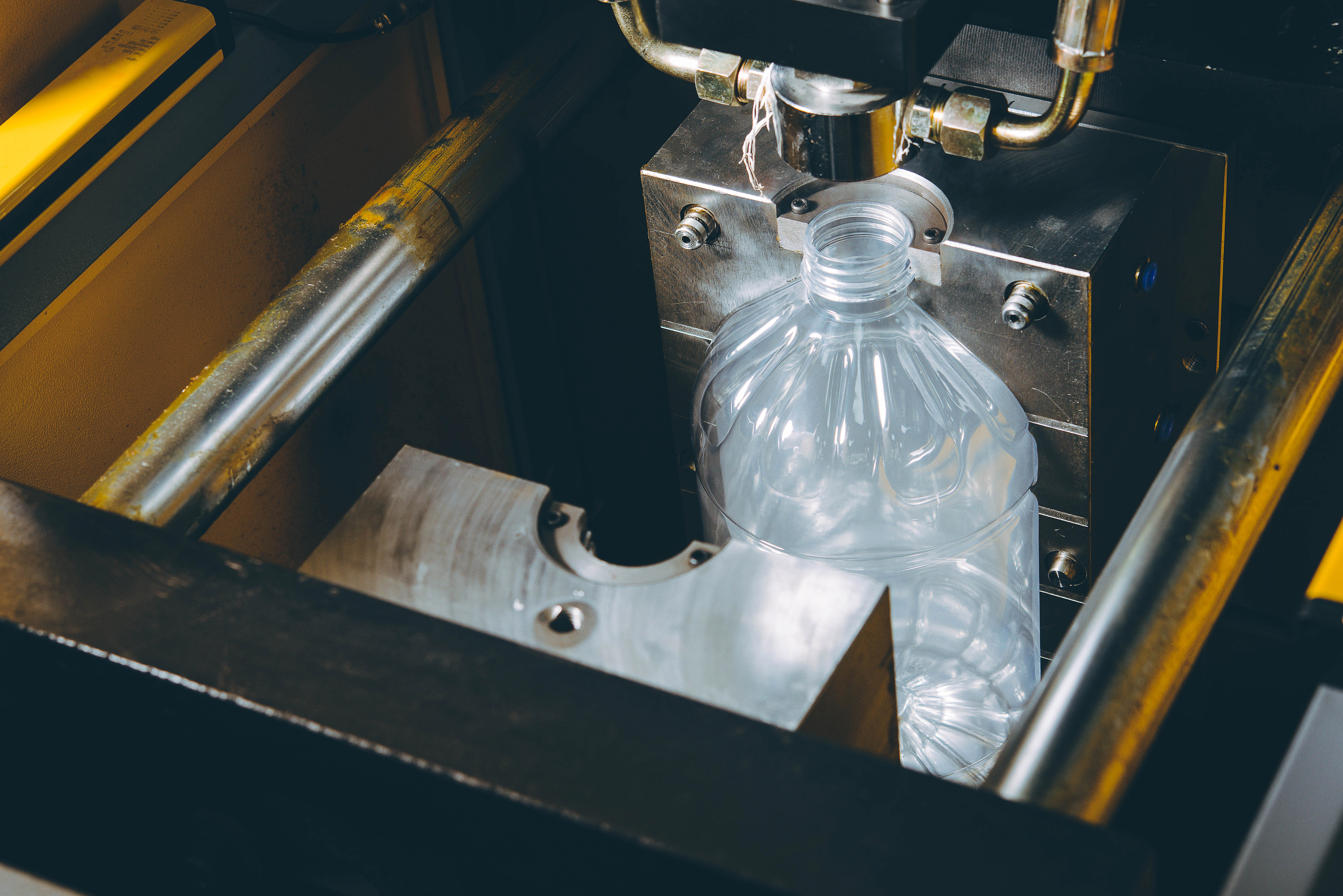 A high-angle view of a blow-mold cavity with a plastic water jug entirely shaped within it.