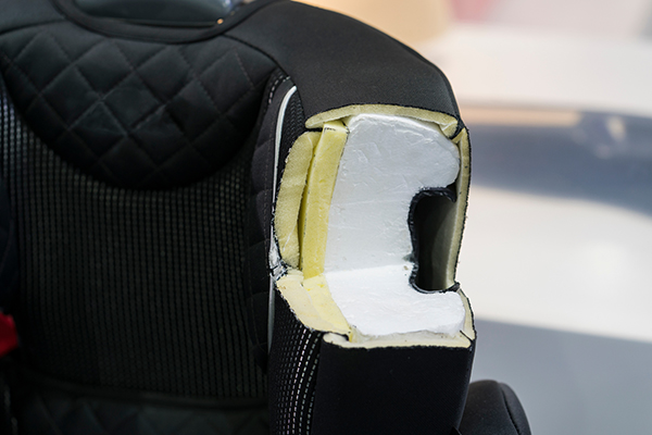 An automotive seat with a section cut out to showcase the inner molding.