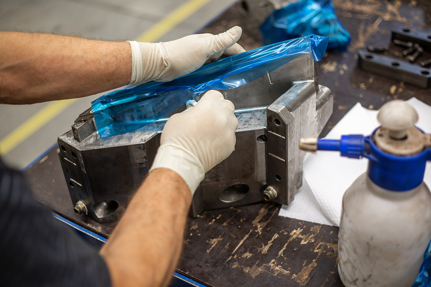 A view of a molding technician's hands during the maintenance and release application process