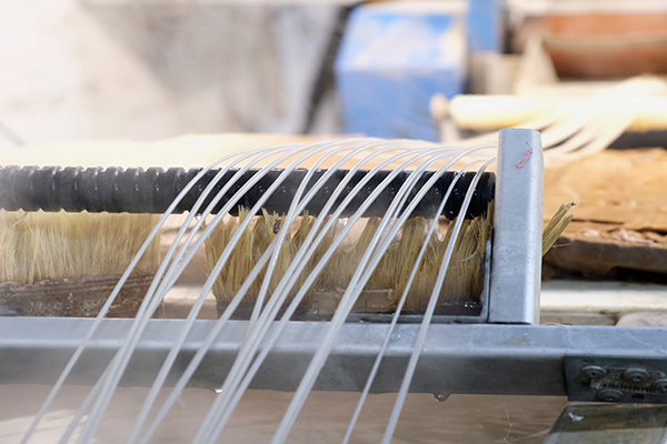 A number of plastic rods being pulled out of an extrusion molding machine