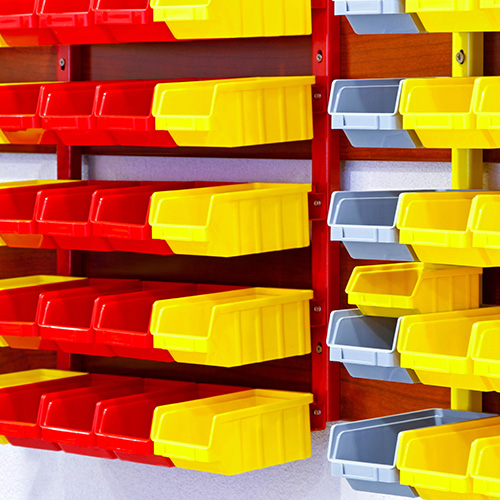 Yellow, red, and gray plastic bins are lined up in rows.